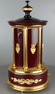 A contemporary maroon lacquer and metal gilt singing bird cigar dispenser carousel, by Reuge