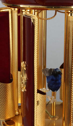 A contemporary maroon lacquer and metal gilt singing bird cigar dispenser carousel, by Reuge